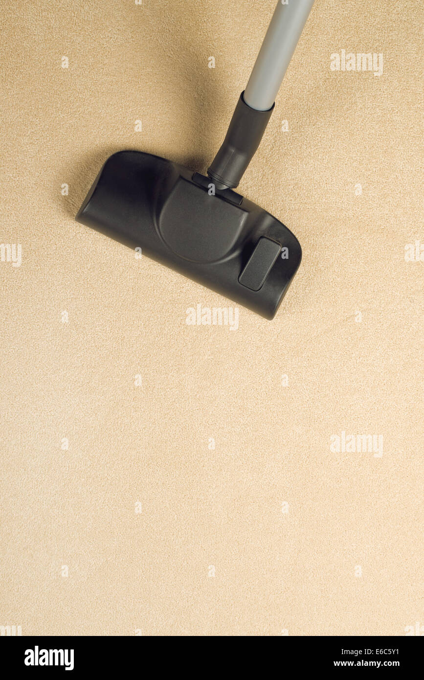 Vacuum Cleaner sweeping Brand New Carpet. Housework and home hygiene. Stock Photo