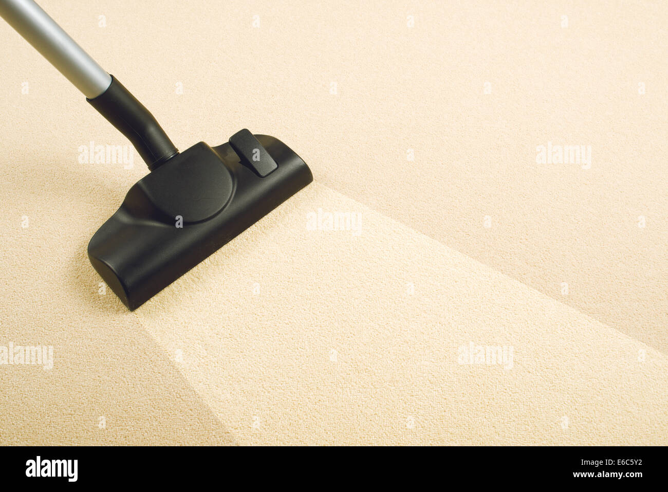 Vacuum Cleaner sweeping Brand New Carpet. Housework and home hygiene. Stock Photo