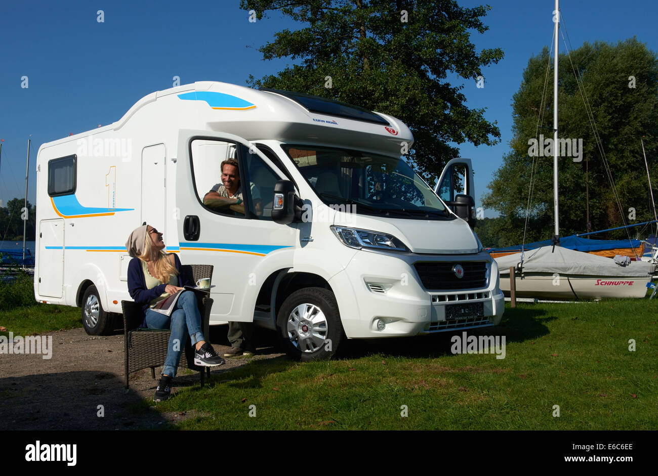 Models Chrissi and Stefan sit in front of a Eura Mobil 'Profila One 690 EB'  camper which is based on the new Fiat Ducato during the preview of the  trade show Caravan-Salon