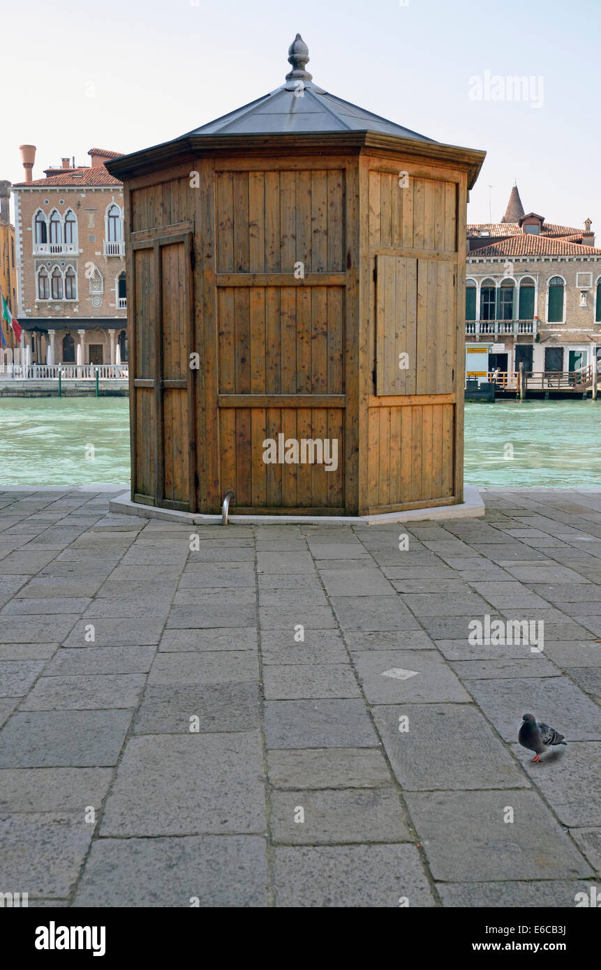Pigeon by wooden kiosk on canal bank, Venice, Italy, Europe Stock Photo