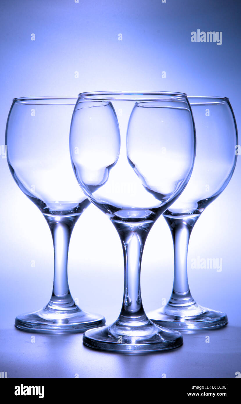 Three empty footed glasses toned in blue color Stock Photo