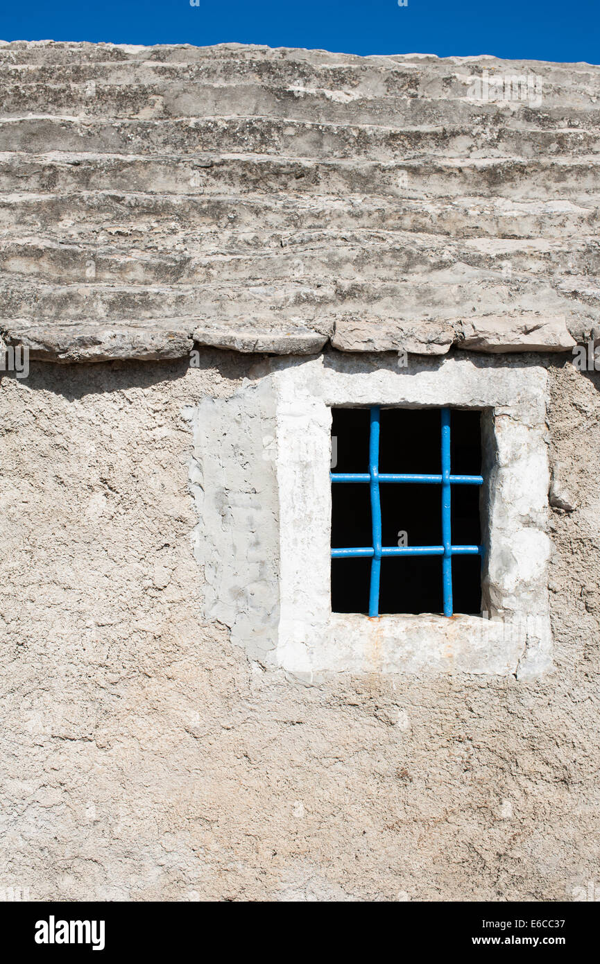 A window with blue steel bars on Mediterranean stone house Stock Photo