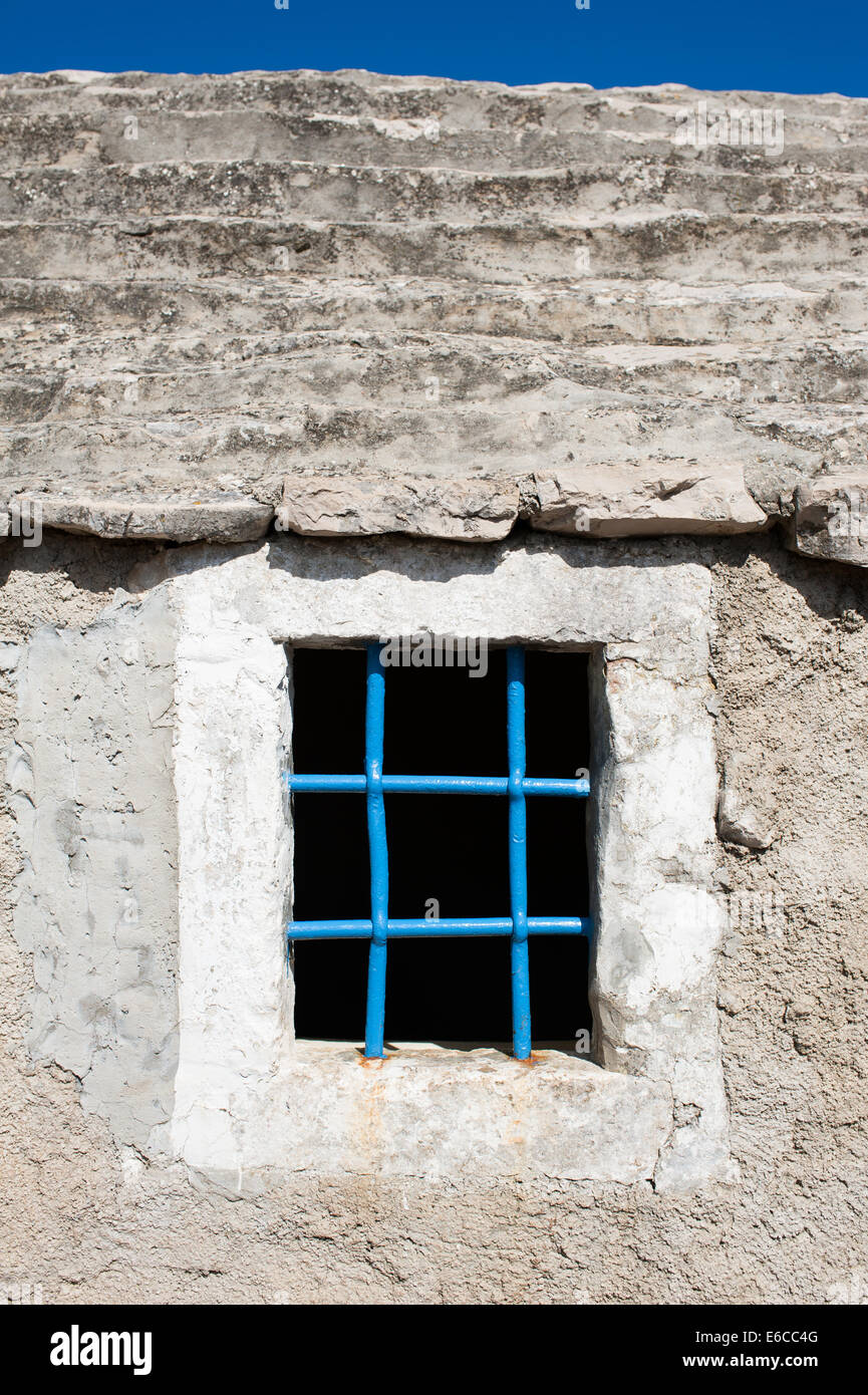 A window with blue steel bars on Mediterranean stone house Stock Photo