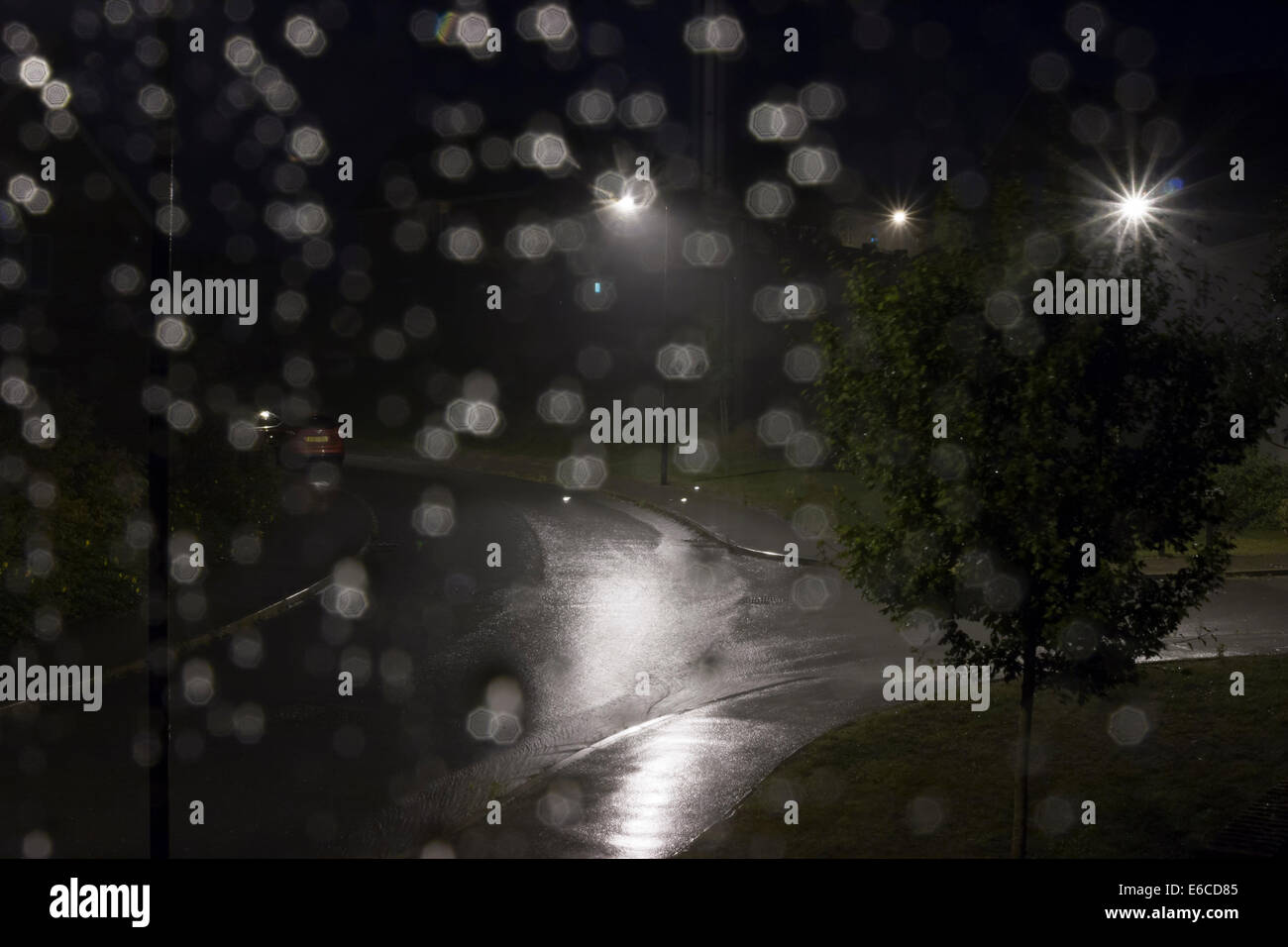 Rain droplets on bedroom window during thunderstorm Stock Photo