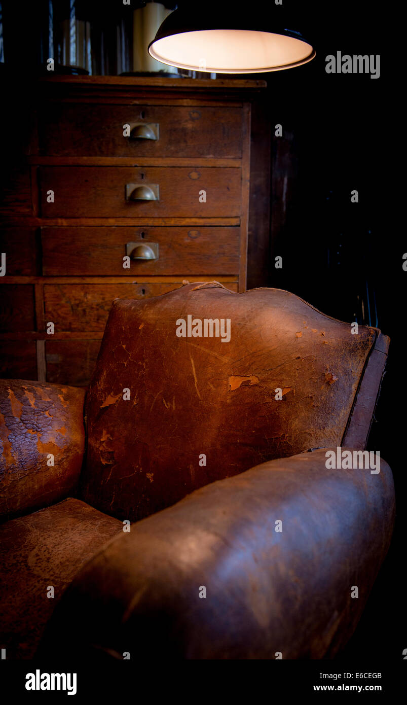 An old leather armchair, chest of drawers and light at a fashionable homewares store, Hastings UK. Stock Photo
