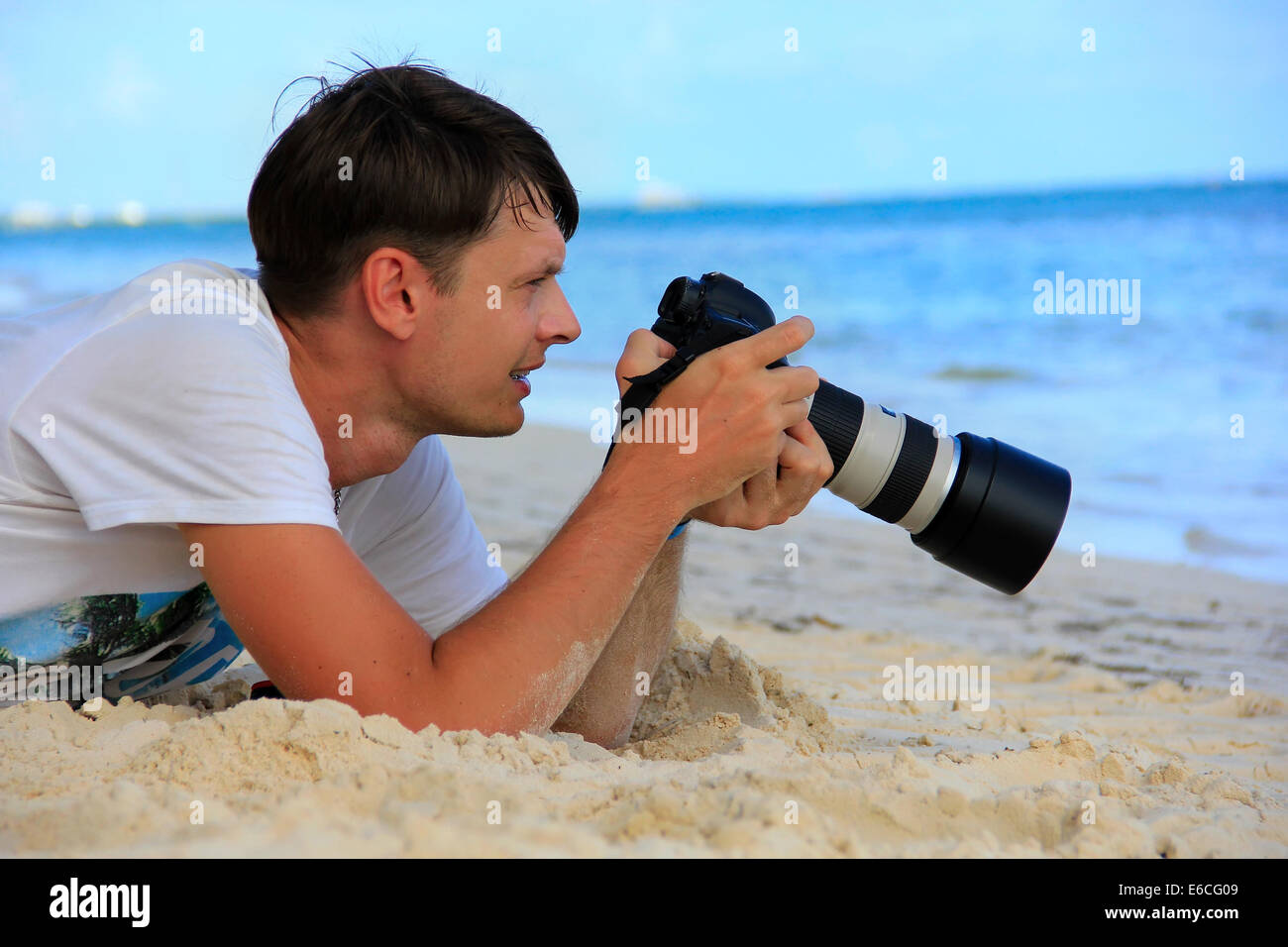 man on the Caribbean beach with a camera Stock Photo