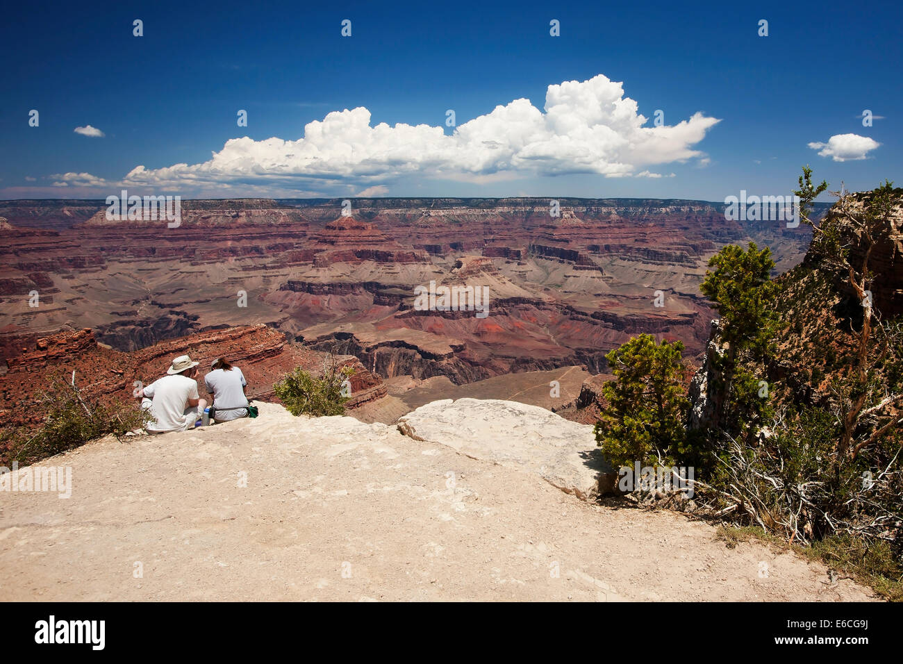 Two Tourists sitting at the South Rim of Grand Canyon Stock Photo