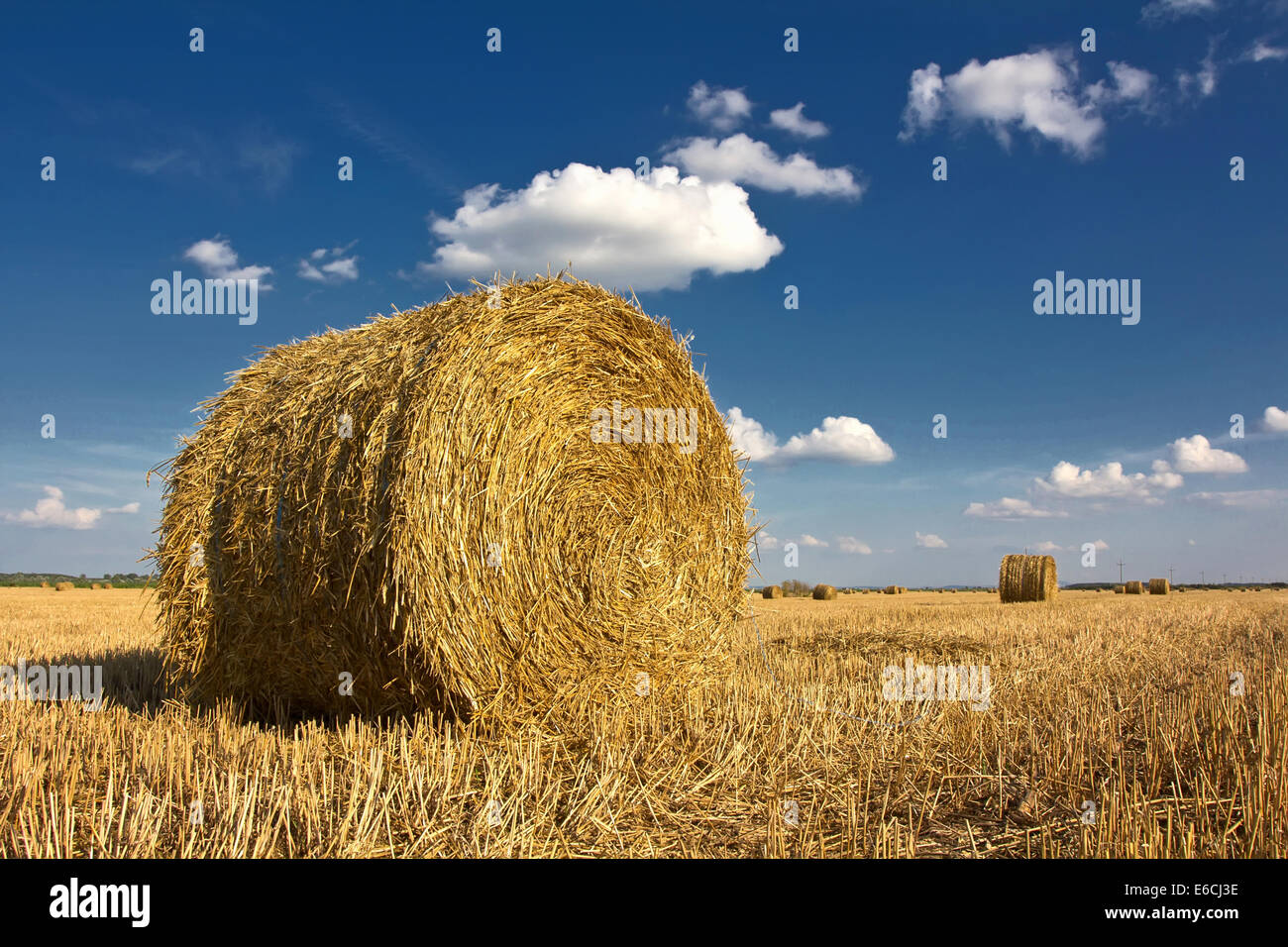 Straw bales on farmland with blue sky and clouds Stock Photo - Alamy