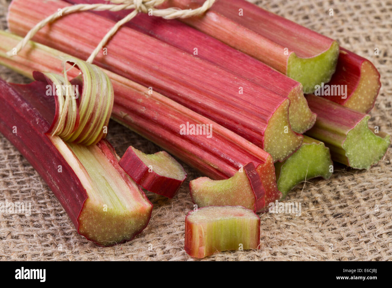 Rhubarb stalks on jute background Stock Photo