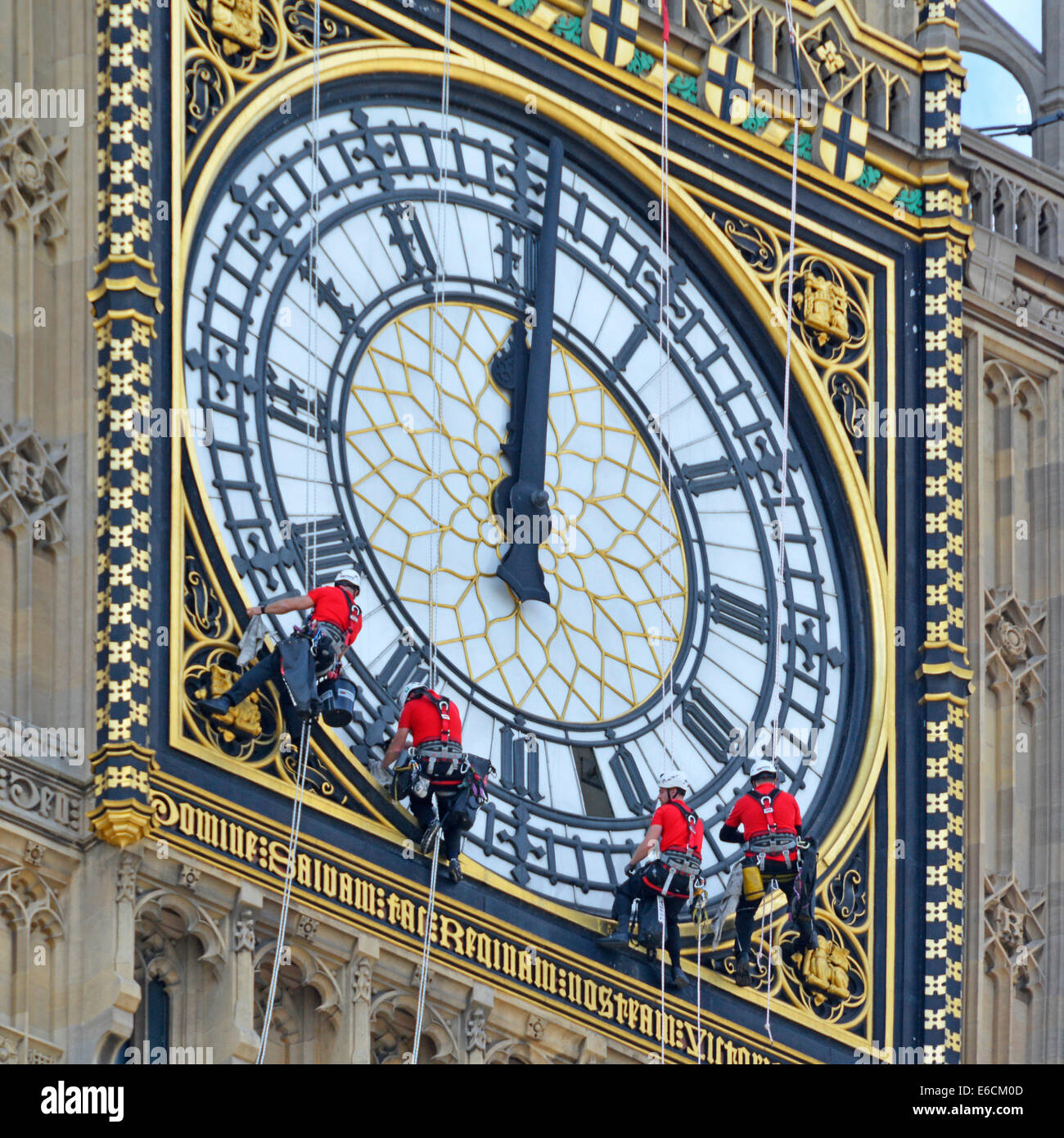 Group of cleaners abseiling Big Ben to clean the iconic clock face with hands set to wrong time of 12 noon or midnight Westminster London England UK Stock Photo