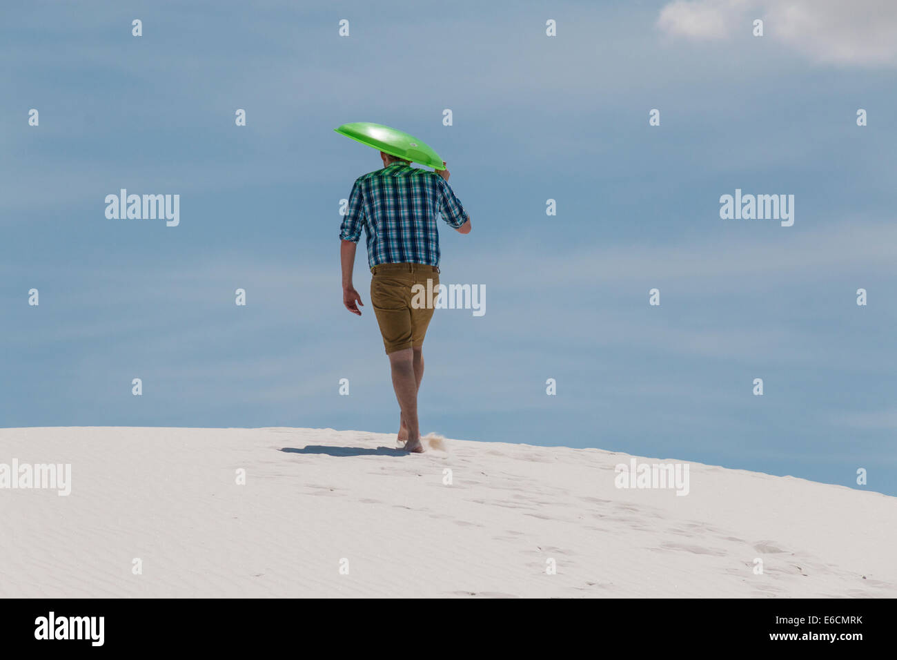 Hiker with sled walking on sand dunes in White Sands National Park (formerly National Monument) in New Mexico. Stock Photo