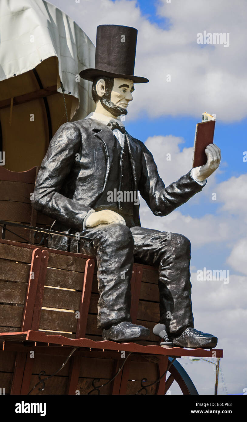The Railsplitter Covered Wagon features Abraham Lincoln sitting on a covered wagon reading a book Stock Photo
