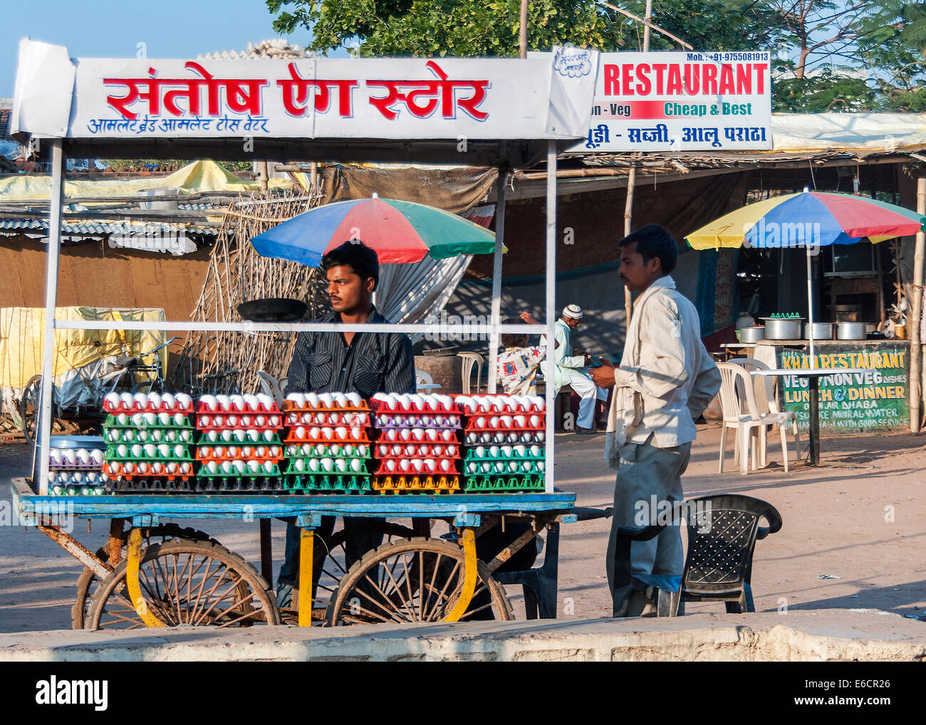 Specialized vendor sells fresh eggs from his rolling cart on the street in the evening sun. Stock Photo