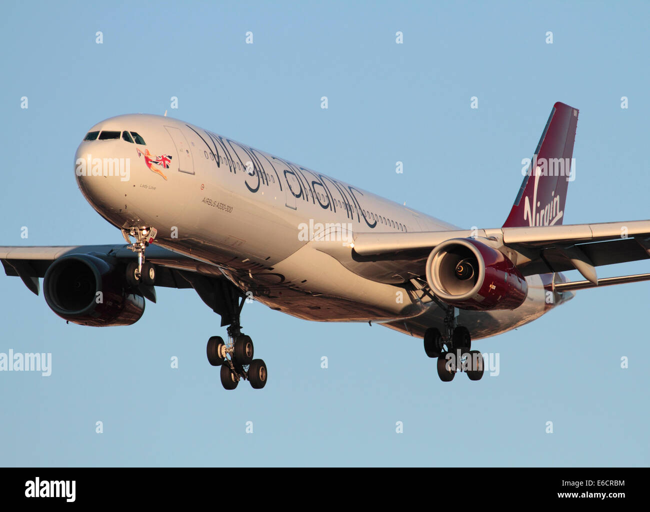 Virgin Atlantic Airways Airbus A330-300 long haul passenger jet plane flying on approach at sunset against a clear blue sky. Closeup front view. Stock Photo