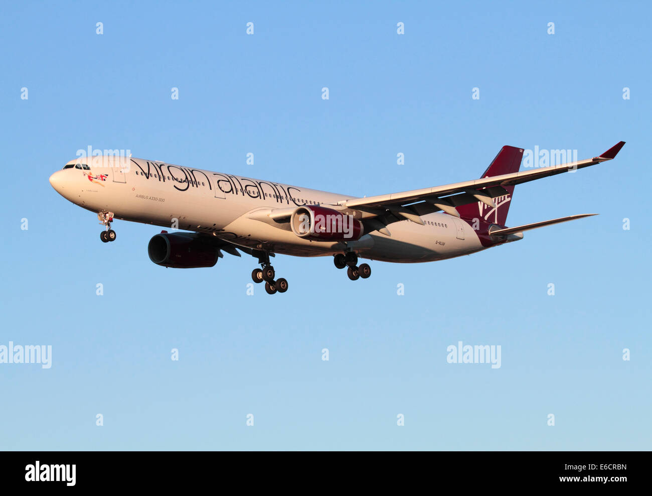 Virgin Atlantic Airways Airbus A330-300 commercial jet plane flying on approach at sunset against a clear blue sky. Long haul air travel and flights. Stock Photo