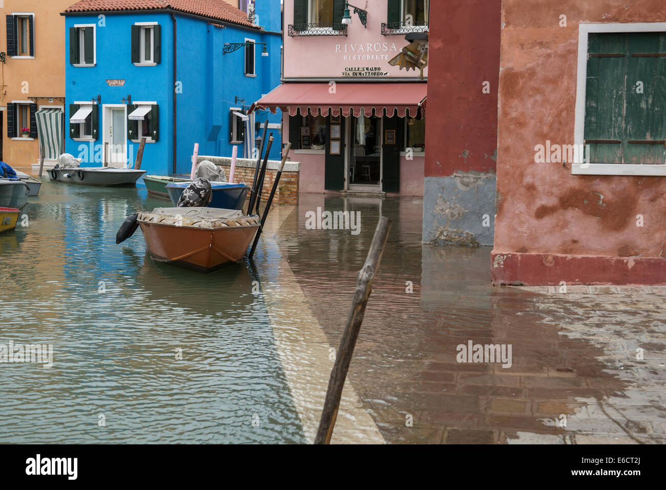 The main canal begins to overflow and flood on the Island of Burano in