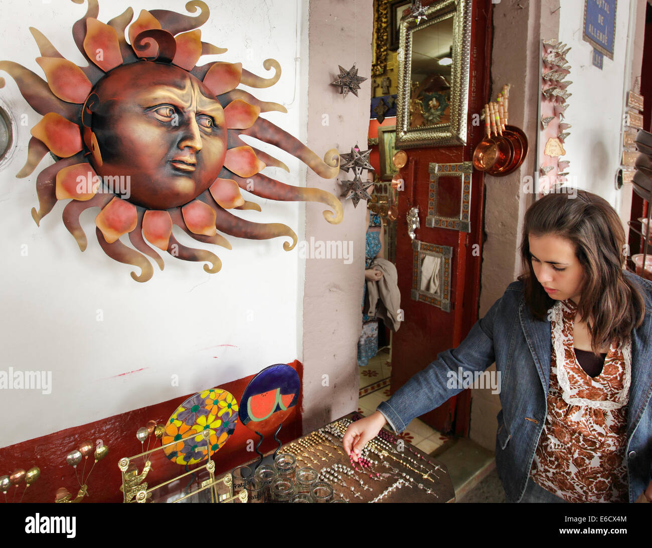 The sun gives a stern look to a tourist shopping in a street market in Patzcuaro, Michoacan, Mexico. Stock Photo