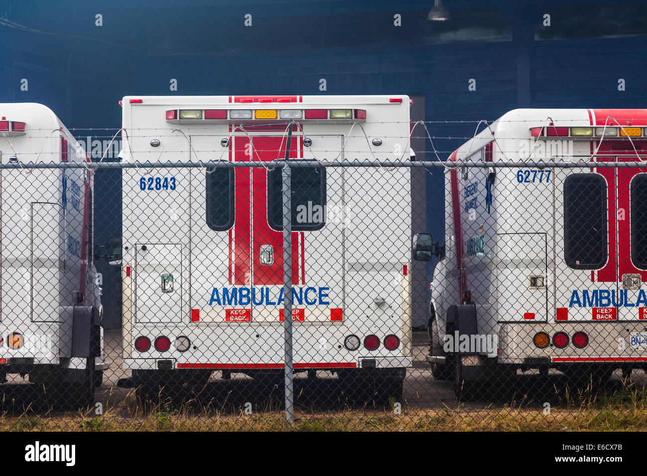 Old ambulances stored behind security fencing, Vancouver, Canada Stock