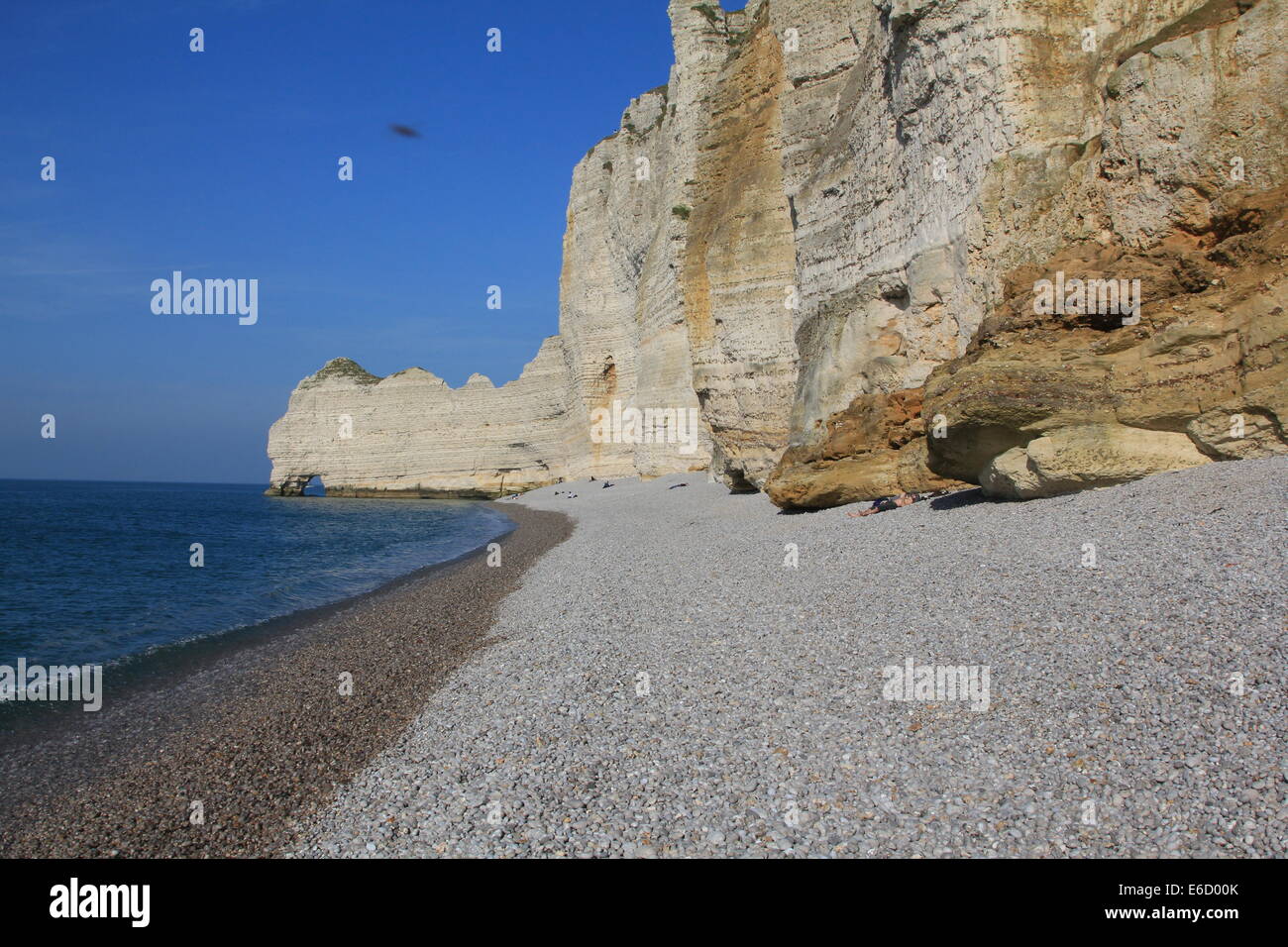 Etretat Étretat pebble beach with layered sedimentary limestone cliffs ...