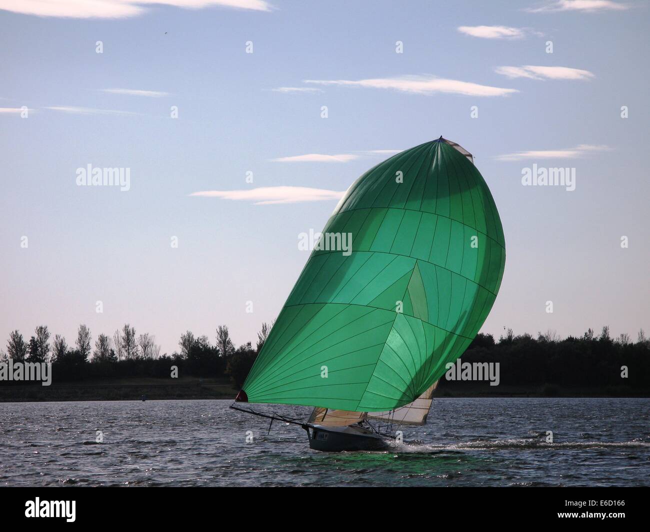 Dinghy sailboat sailing on a lake under a blue sky Stock Photo Alamy