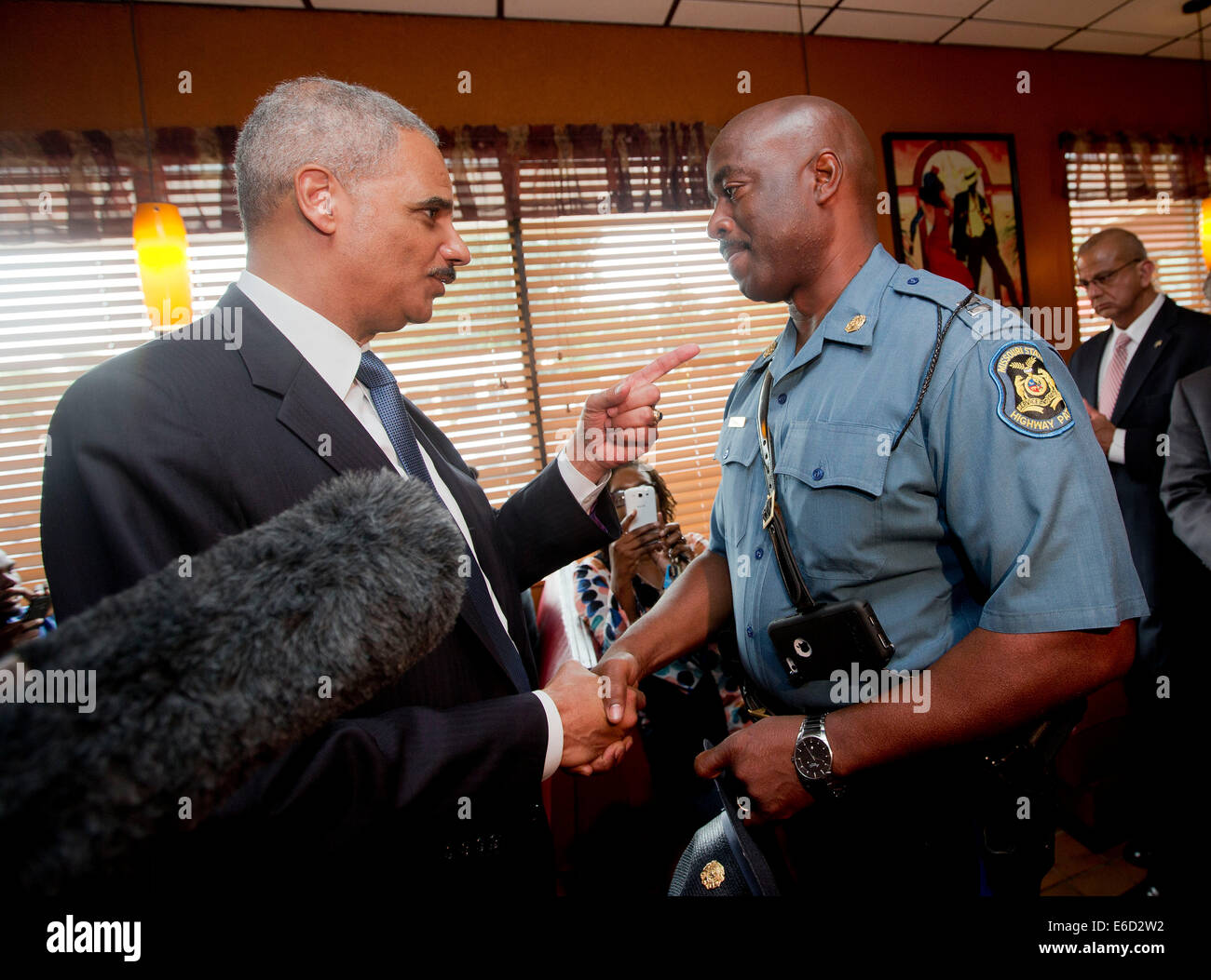 Ferguson, Mo. 20th Aug, 2014. United States Attorney General Eric Holder, left, talks with Capt. Ron Johnson, right, of the Missouri State Highway Patrol at Drake's Place Restaurant, Wednesday, Aug. 20, 2014 in Florrissant, Mo. Holder traveled to the St. Louis-Area to oversee the federal government's investigation into the shooting of 18-year-old Michael Brown by a police officer on Aug. 9th. Holder promised a 'fair and thorough' investigation into the fatal shooting of a young black man, Michael Brown Credit:  dpa picture alliance/Alamy Live News Stock Photo