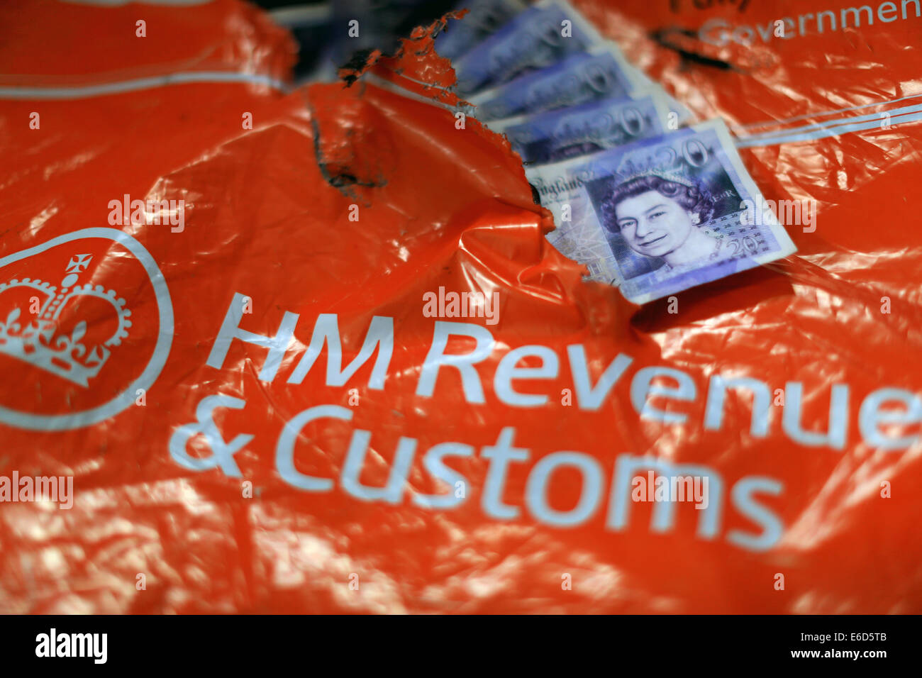 HM Revenue & Customs, Her Majesty's Revenue and Customs, torn and ripped orange package of the HMRC with £20 notes Stock Photo