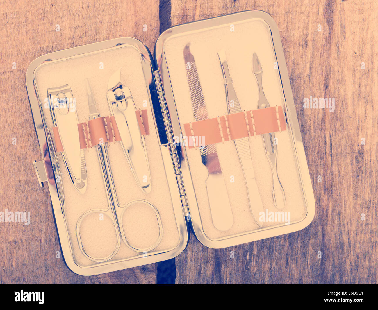 Classic metal kit of nail scissors and manicure tools on wooden background with vintage filter Stock Photo