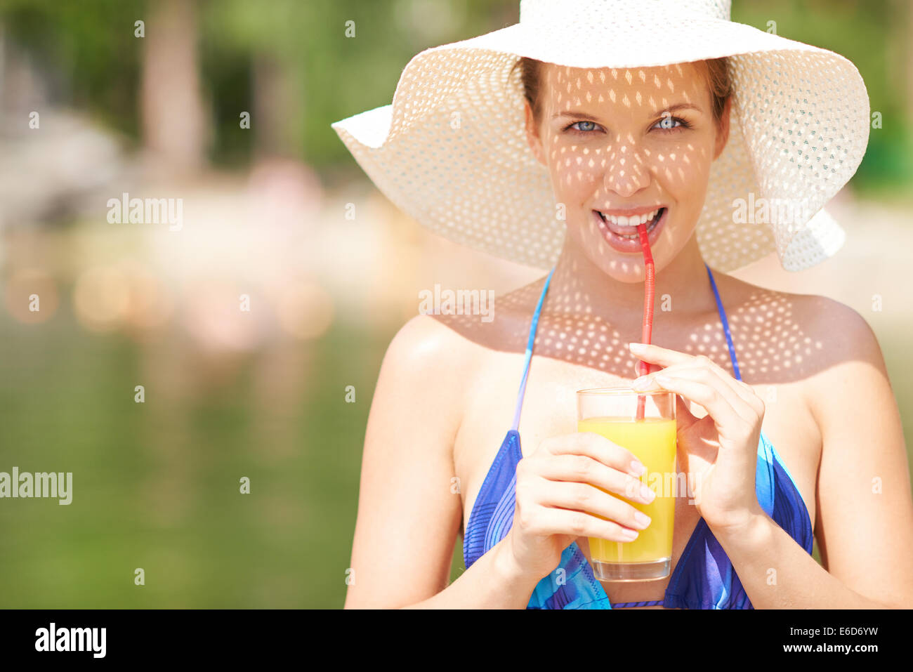 Woman in bikini drinking orange juice Stock Photo