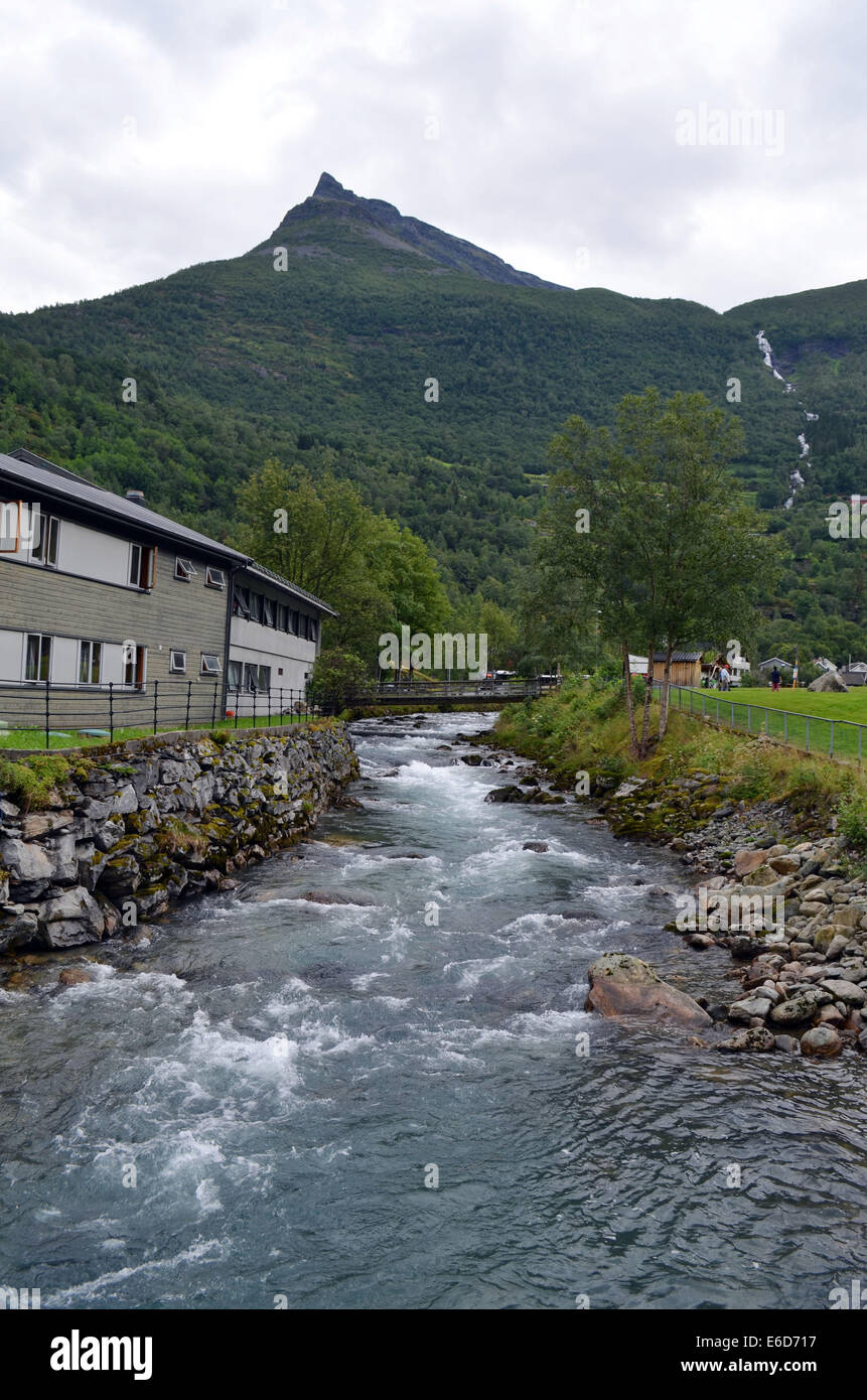 Geiranger Fford. A fast flowing stream runs alongside the cafe and buildings at Geiranger fjord. Stock Photo