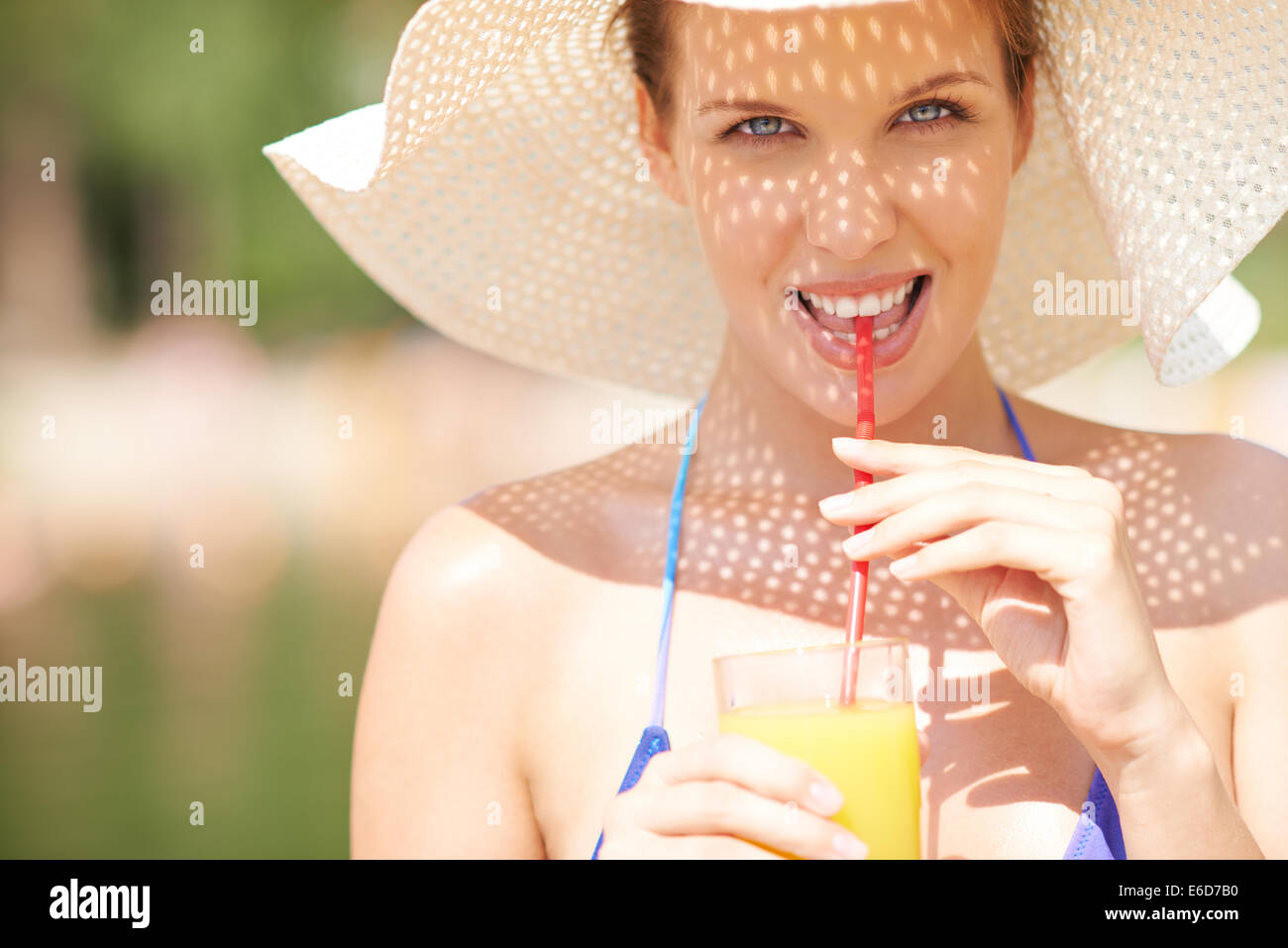 Portrait of a woman in bikini drinking juice Stock Photo