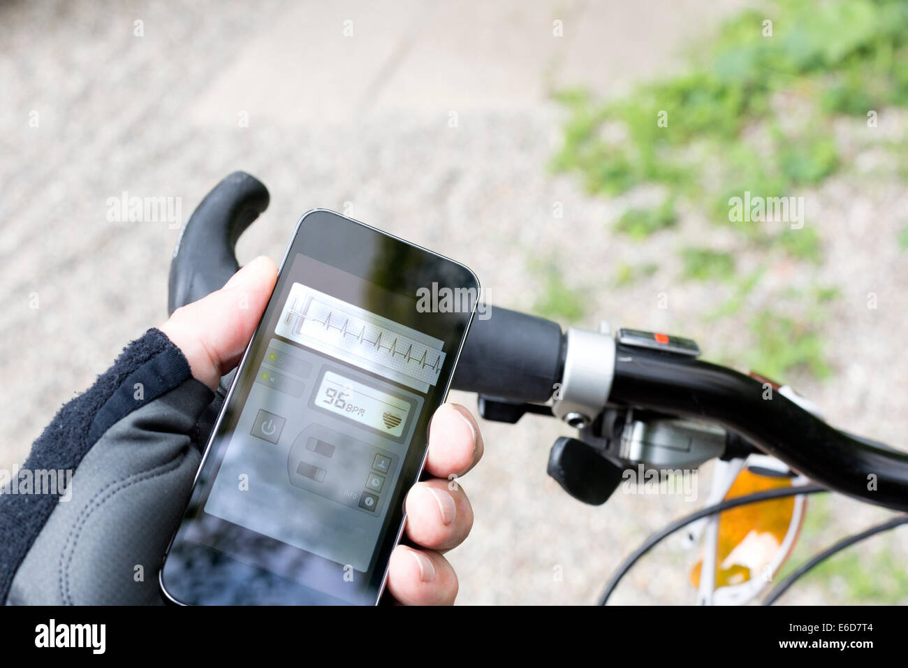 Hand of mountain biker holding smartphone with heart rate monitor Stock Photo