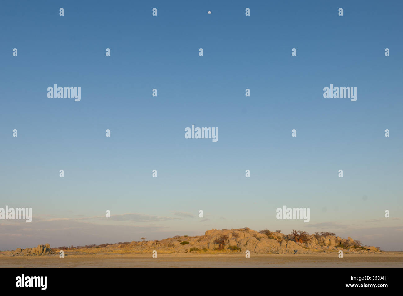 Moon over the granite mass of Kubu Island (Lekhubu) in the early morning, Magkadigkadi Pan, Botswana Stock Photo