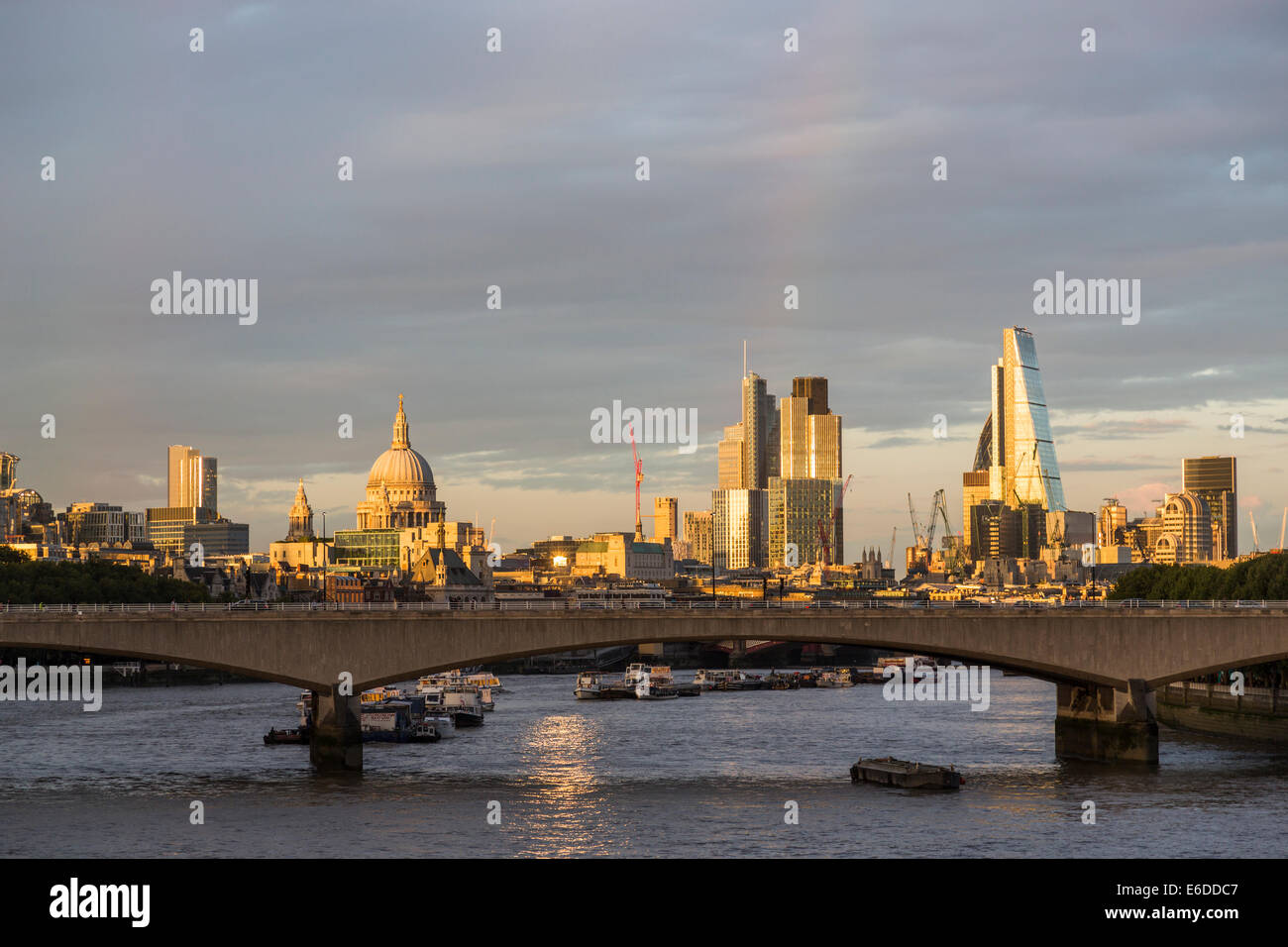 London evening skyline with rainbow: Waterloo Bridge, River Thames, St Paul's Cathedral, Cheesegrater, Tower 42, modern financial district landmarks Stock Photo