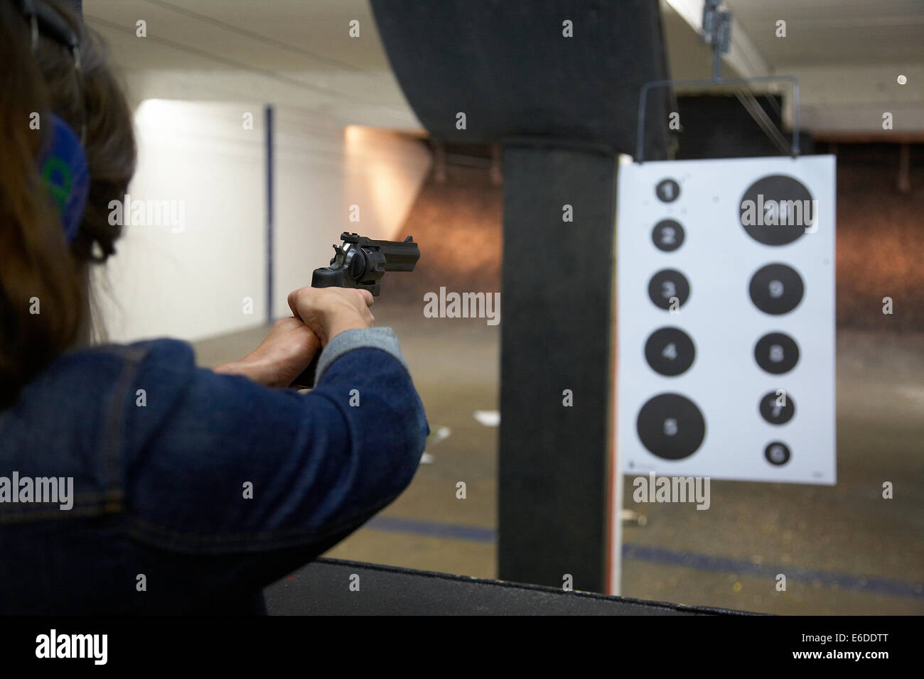 Young woman shooting a handgun at a shooting range in Minneapolis USA