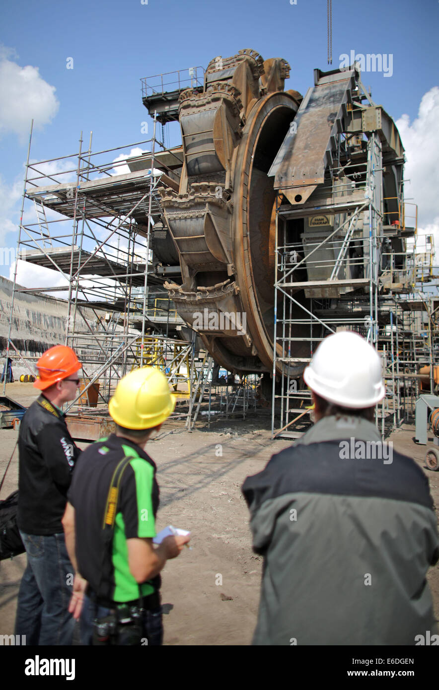 Poedelwitz, Germany. 21st Aug, 2014. Journalists stand in front of a bucket-wheel excavator during a general overhaul at the surface mine Vereintes Schleenhain near Poedelwitz, Germany, 21 August 2014. Brown coal company Mibrag will conduct a complex overhaul of a bucket-wheel excavator and of a stacker from July 2014 till October 2014. Photo: JAN WOITAS/DPA/Alamy Live News Stock Photo