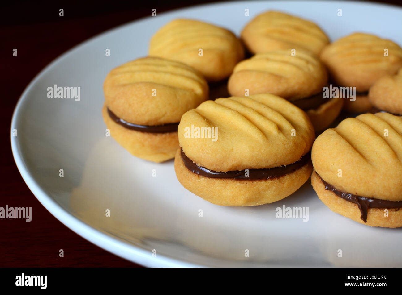 Closeup of a plate of biscuits oozing with chocolate hazelnut spread