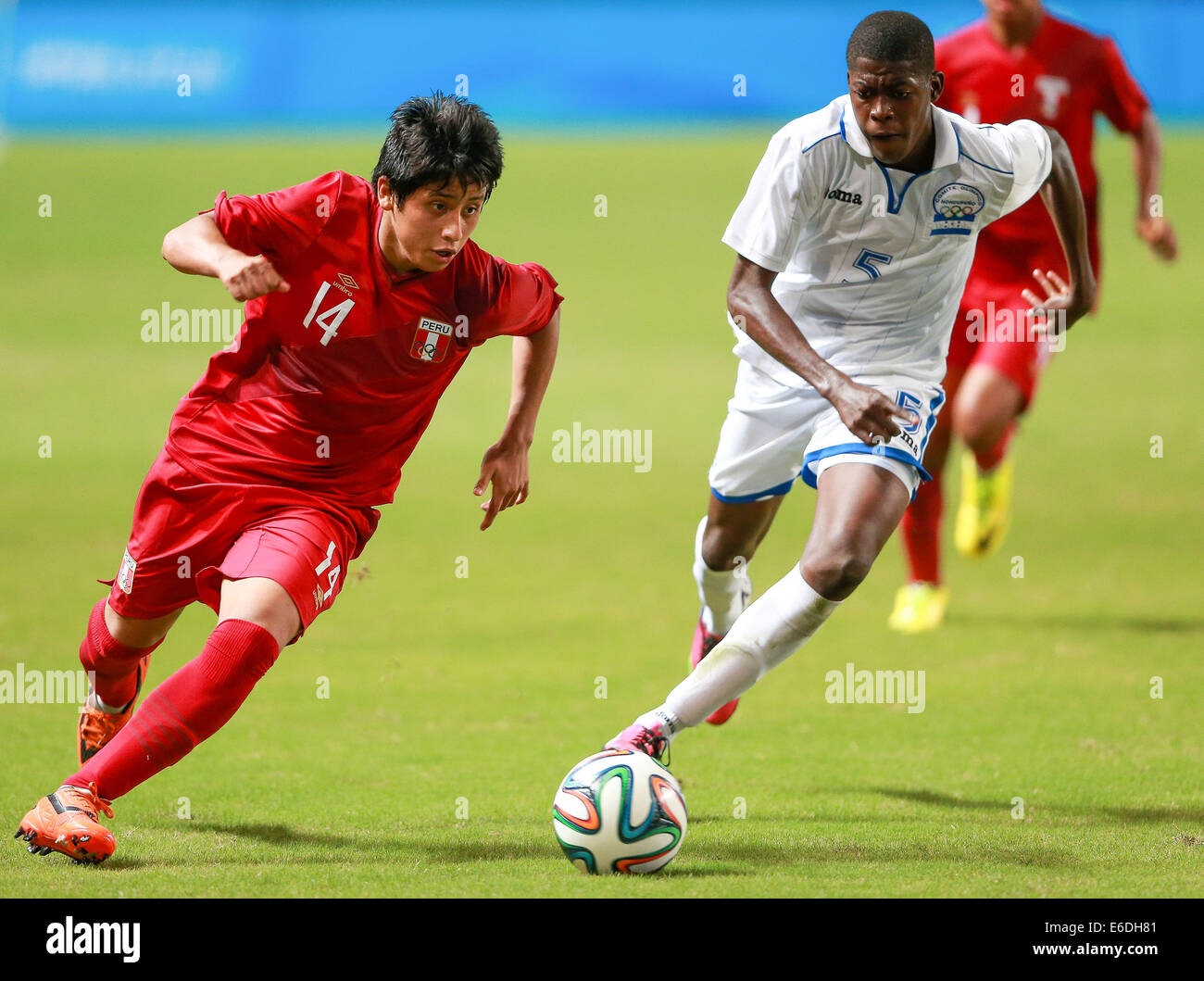 Nanjing, China's Jiangsu Province. 21st Aug, 2014. Franklin Gil(L) of Peru competes in the preliminary round of football event during Nanjing 2014 Youth Olympic Games in Nanjing, capital of east China's Jiangsu Province, on Aug. 21, 2014. Team Peru won team Honduras. Credit:  Chen Yichen/Xinhua/Alamy Live News Stock Photo