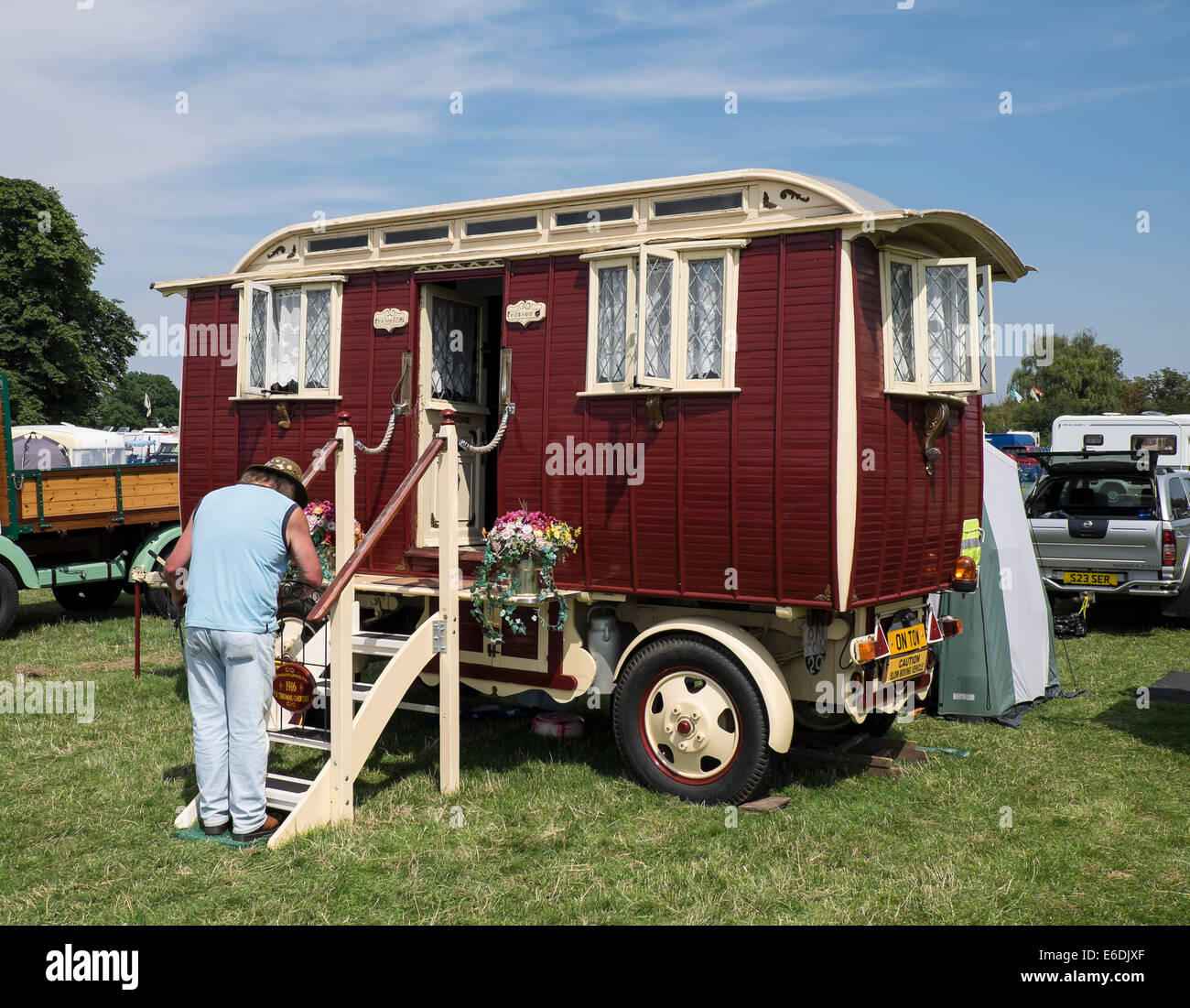 Owner at steps to 1916 vintage showman's living van at show ground for Cambridgeshire Steam Rally and Country Fair England Stock Photo