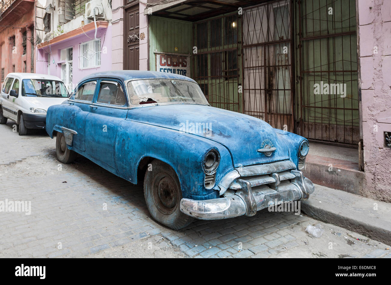 Dilapidated blue vintage Oldsmobile car with taped broken windscreen parked on the roadside in a street in central Havana, Cuba Stock Photo