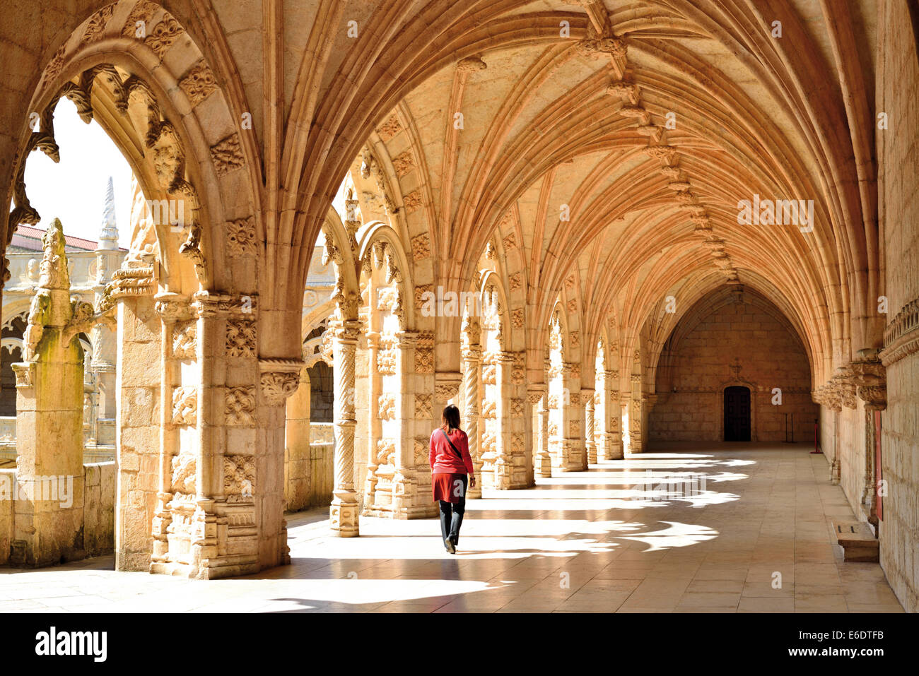 Portugal, Lisbon: Female tourist walking inside of a corridor at  the medieval cloister of the Monastery of St. Jerome Stock Photo