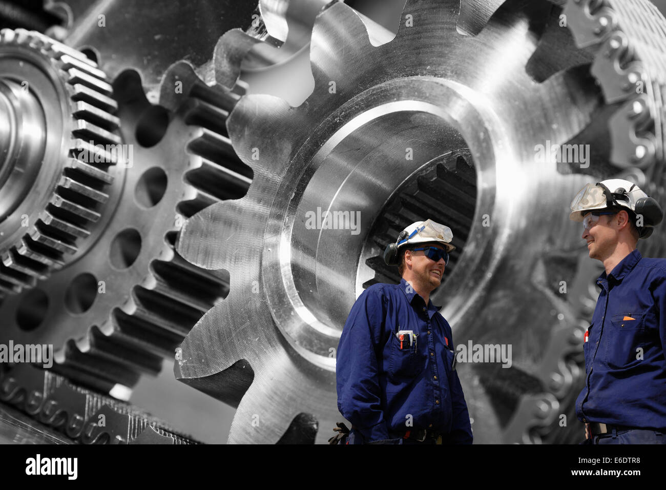 mechanics, engineers and giant cogwheel machinery Stock Photo