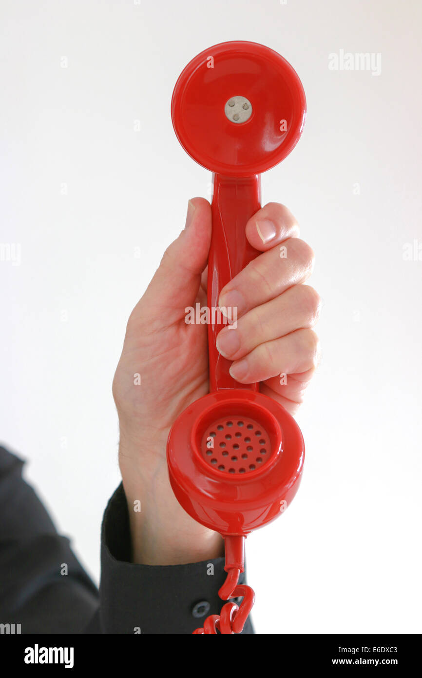 Man's hand holding old red telephone receiver. Stock Photo