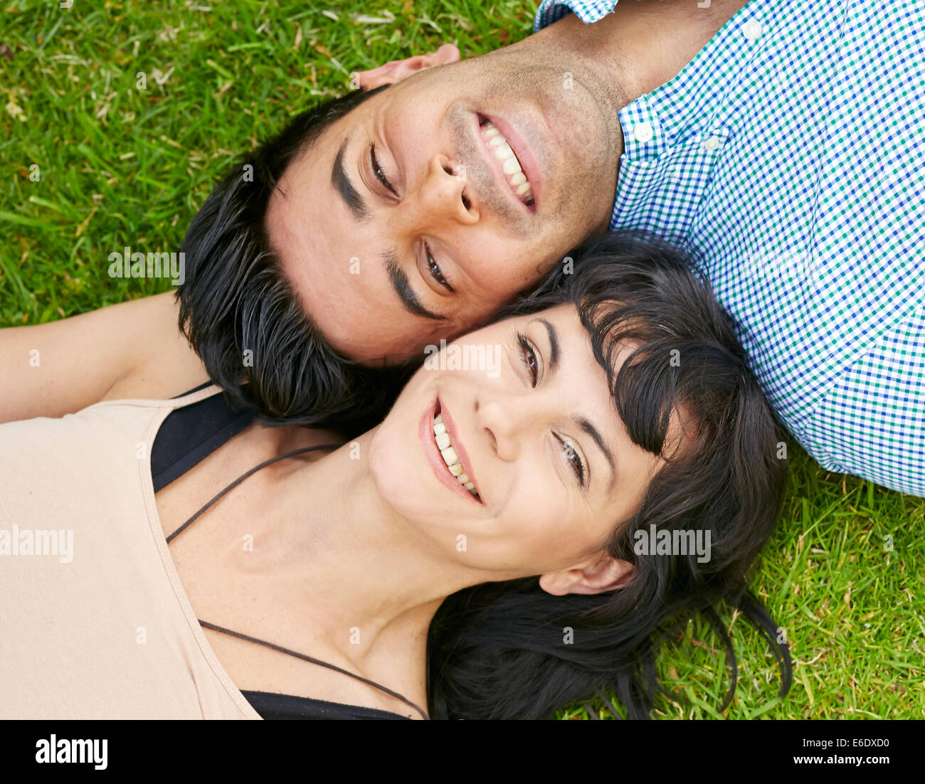 Couple lying on grass together Stock Photo