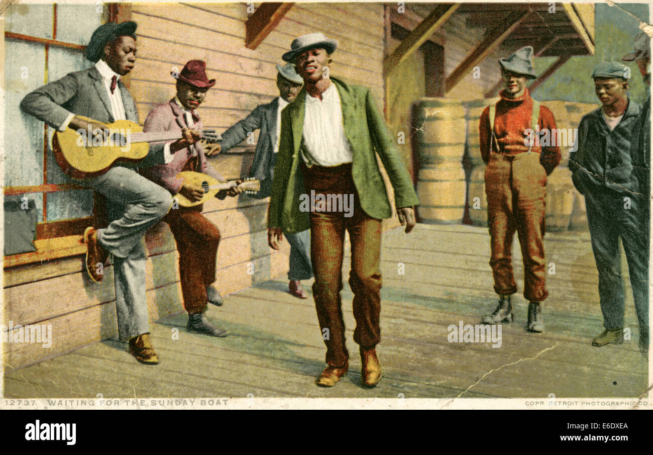 Group of African-American Men Playing Guitars and Dancing, "Waiting for the Sunday Boat", USA, Hand-Colored Postcard, circa 1910 Stock Photo