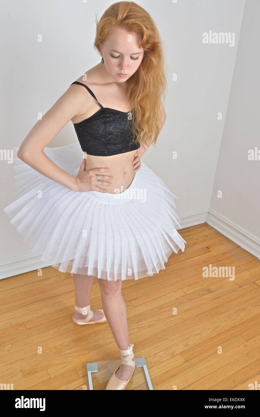 Teen with pointe ballet shoes standing on weight scale. Stock Photo