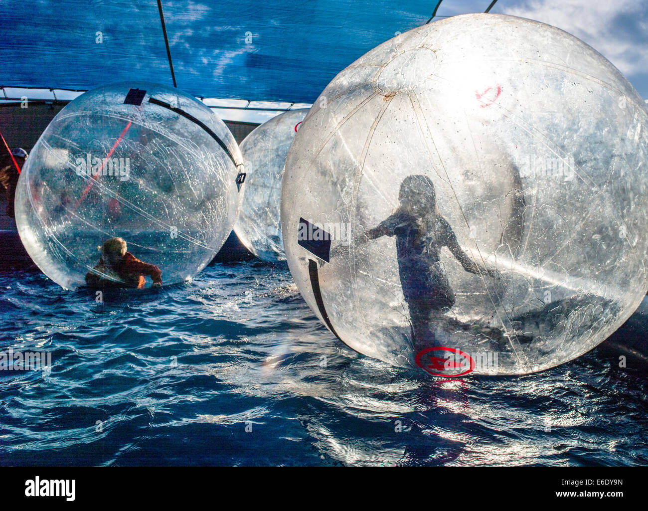 Children play in Water Bubbles, large inflated balls floating in a pool