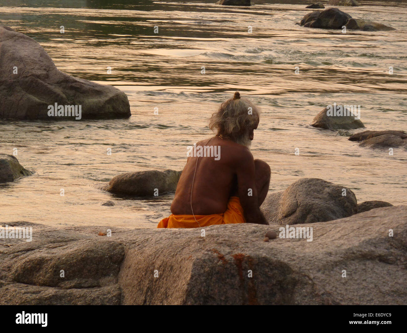 Saddhu in the river between rocks on the bank of the Betwa River in Orchha, Madhya Pradesh, Bundelkhand region, India, Asia Stock Photo