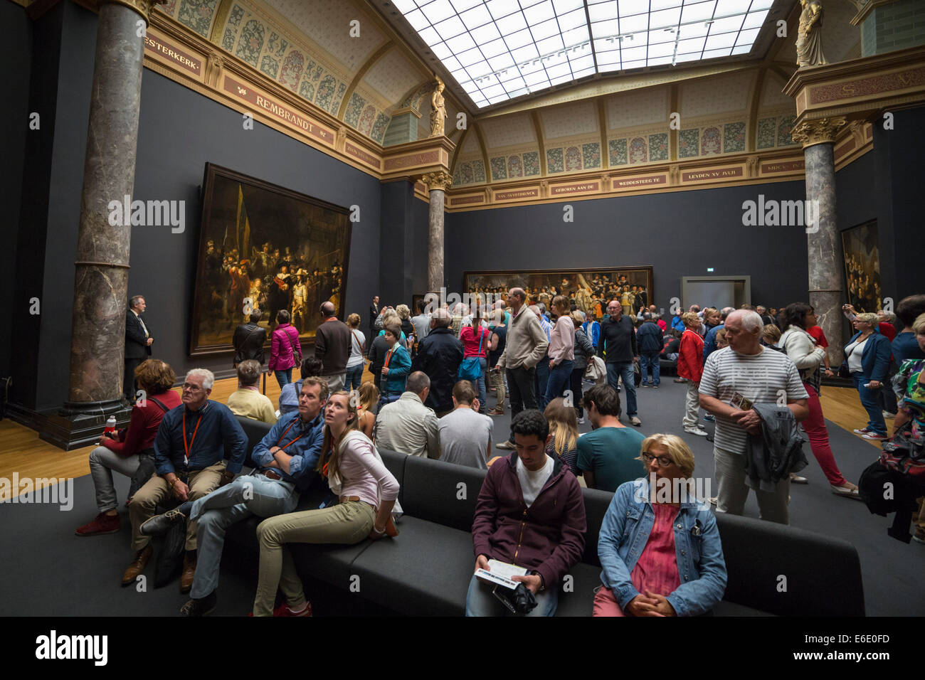 People watching 'the Nachtwacht' and other famous paintings by Rembrandt van Rijn at the Rijksmuseum in Amsterdam. Stock Photo