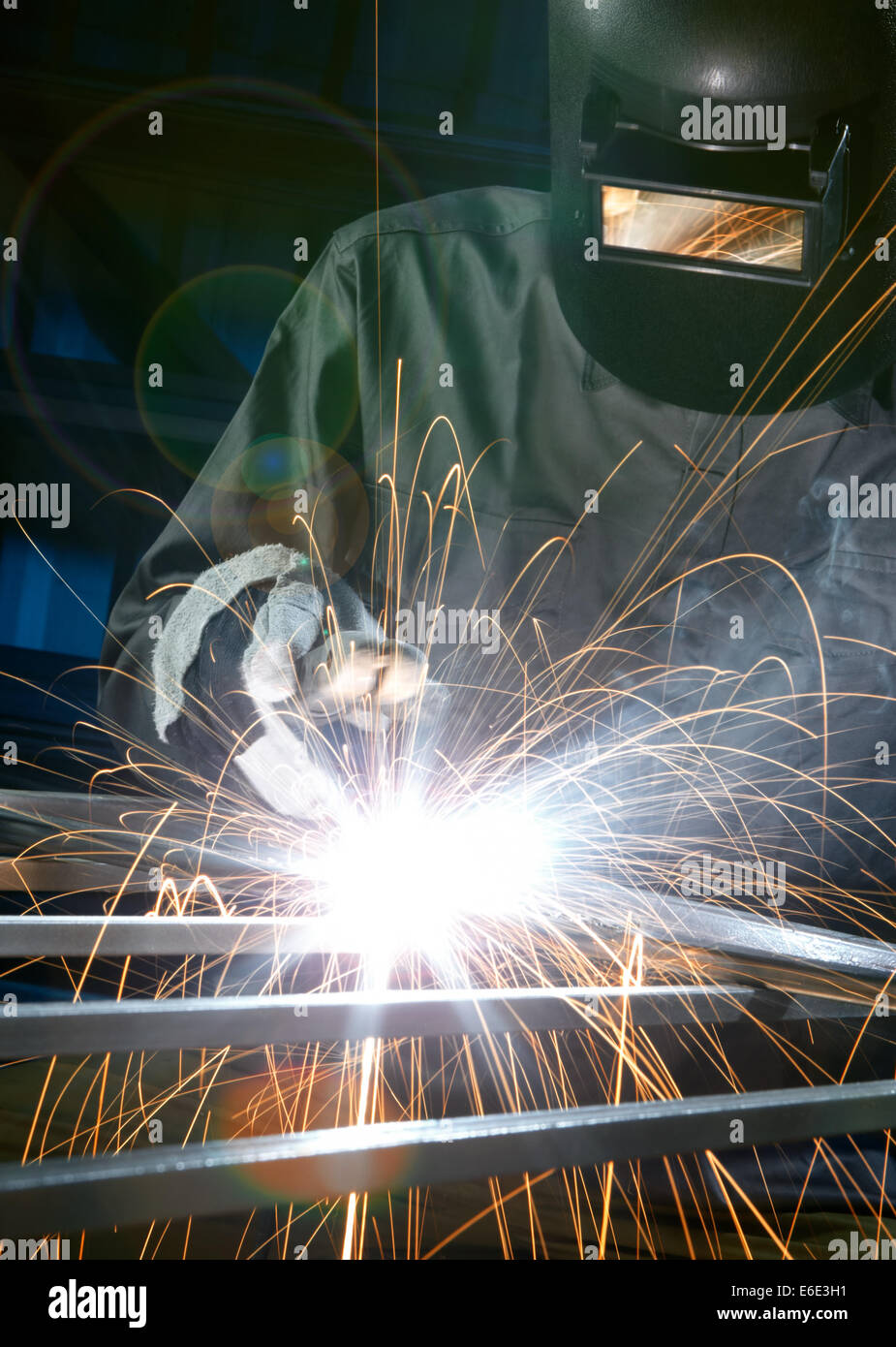 man welding with reflection of sparks on visor Stock Photo