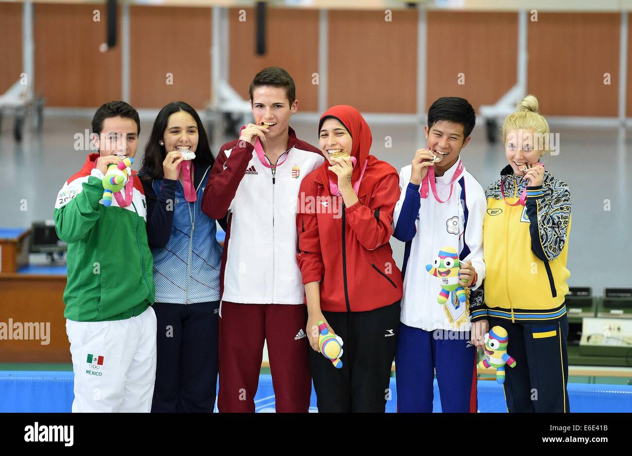 Nanjing, China's Jiangsu Province. 22nd Aug, 2014. Gold medalist Istvan Peni (3rd, L) of Hungary and Hadir Mekhimar (3rd, R) of Egypt, sliver medalist Jose Santos Valdes Martinez (1st, L) of Mexico and Fernanda Russo (2nd, L) of Argentina, bronze medalist Lu Shao-Chuan (2nd, R) of Chinese Taipei and Viktoriya Sukhorukova of Ukraine pose on the podium during the awarding ceremony of the 10m Air Rifle Mixed International Teams Competition at Nanjing 2014 Youth Olympic Games in Nanjing, east China's Jiangsu Province, August 22, 2014. Credit:  Huang Xiaobang/Xinhua/Alamy Live News Stock Photo